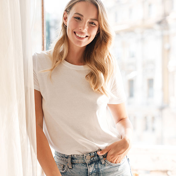 Young Blonde Woman Standing Beside Window