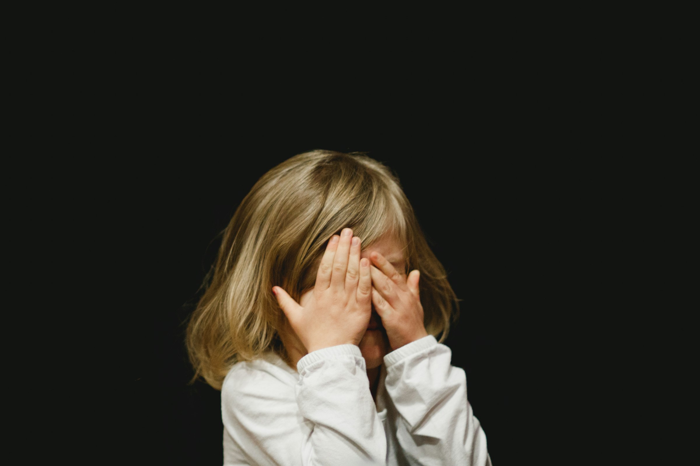 Child with her hands over her eyes