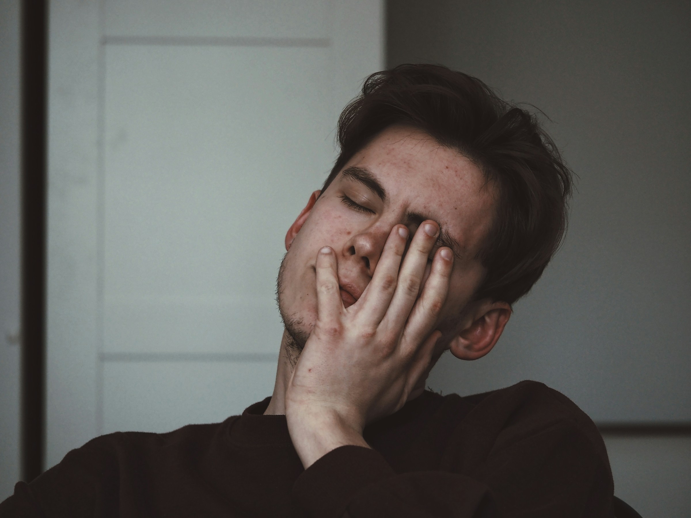 Young man with his hand over his face