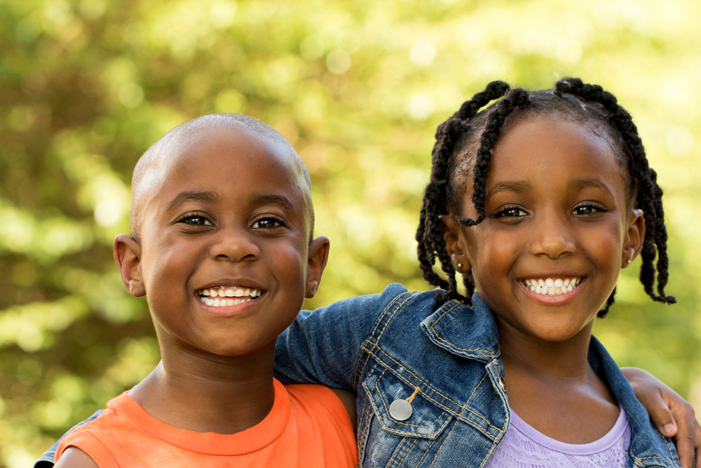 little boy and girl smiling with arms around each other
